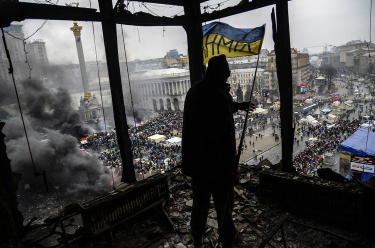 fot. Bulent Kilic / AFP / Getty Images / 20 lutego 2014
Ukraińska flaga, którą jeden z protestujących trzyma w spalonym wskutek zamieszek budynku